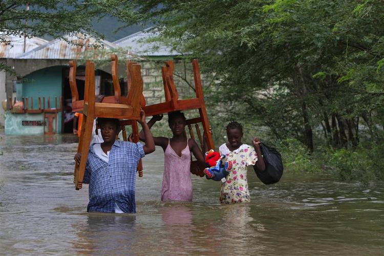 Mennesker bjærger deres møbler i det nordlige Haiti, efter at den tropiske storm Hannah har skabt oversvømmelser. 