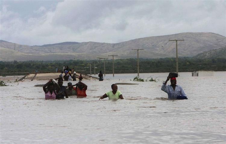 Lokale forsøger at krydse et oversvømmet område i Savan Desole, Haiti. 