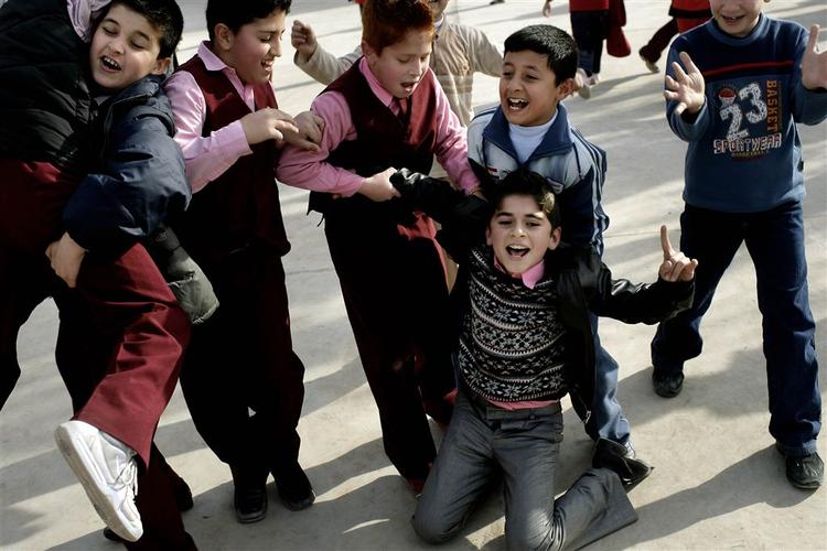 Drenge i Bitwen Skolen i Erbil fejrer sidste skoledag med fodboldkamp i gården. Det vindende hold jubler over sejren. 