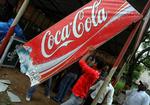 Imens den indiske befolkning raser over pesticider i indisk Coca-Cola, sprøjter landmænd deres marker med læskedrikken. Her hiver en indisk studerende i Kerala et Coca-Cola-banner ned i protest. 