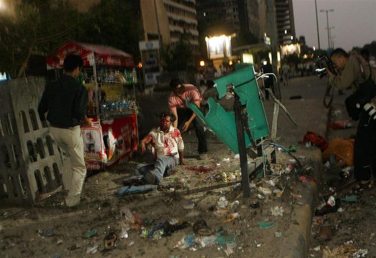 Folk iler til for at hjælpe en såret mand i et af de shoppingområder i New Delhi, der er blevet ramt af en serie af bomber. 
