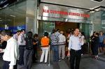 Forsikringshavere i AIG står i kø i Singapore for at ophæve deres policer. 