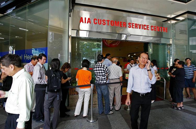 Forsikringshavere i AIG står i kø i Singapore for at ophæve deres policer. 