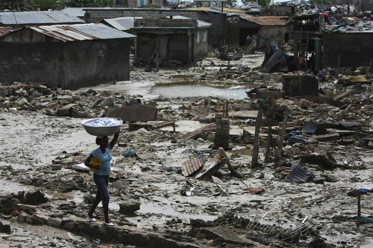 En kvinde bevæger sig gennem den ødelagte havneby Gonaives i Haiti. 