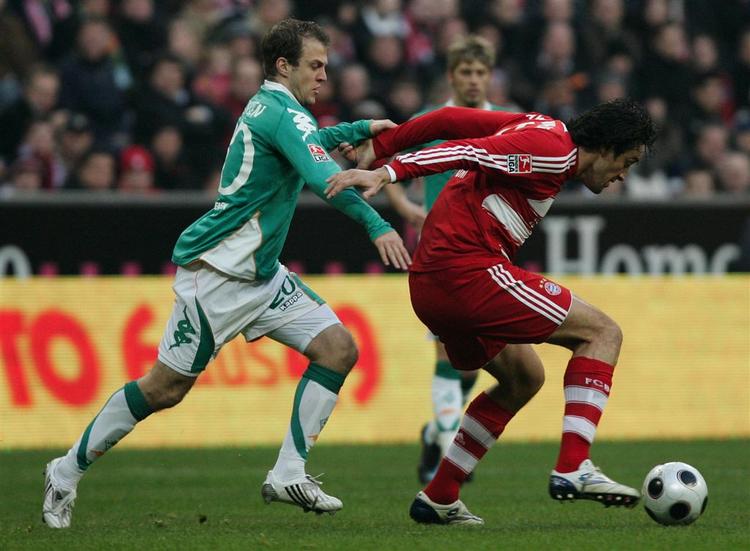 Daniel Jensen i nærkamp med Bayerns Luca Toni i et opgør i tidligere i år. 