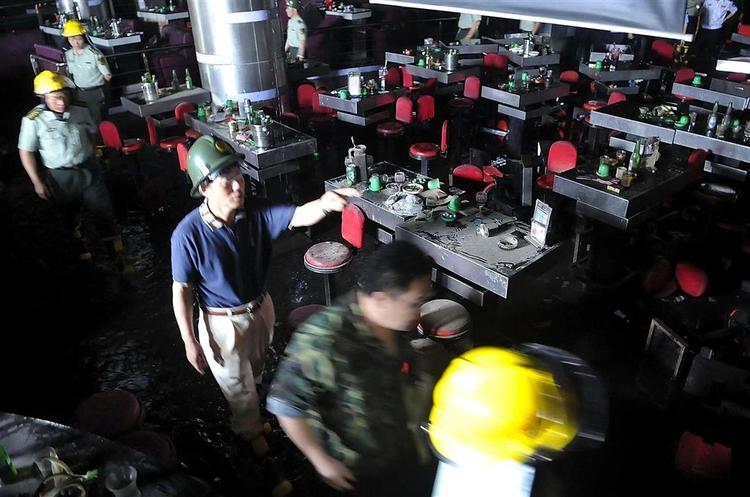 Brandfolk inspicerer skaderne efter branden på et diskotek i Shenzhen som kostede mindst 43 personer livet. 