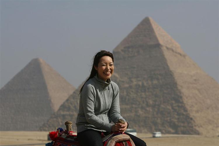 En turist på kamelryg ved Giza pyramiderne i Kairo. 