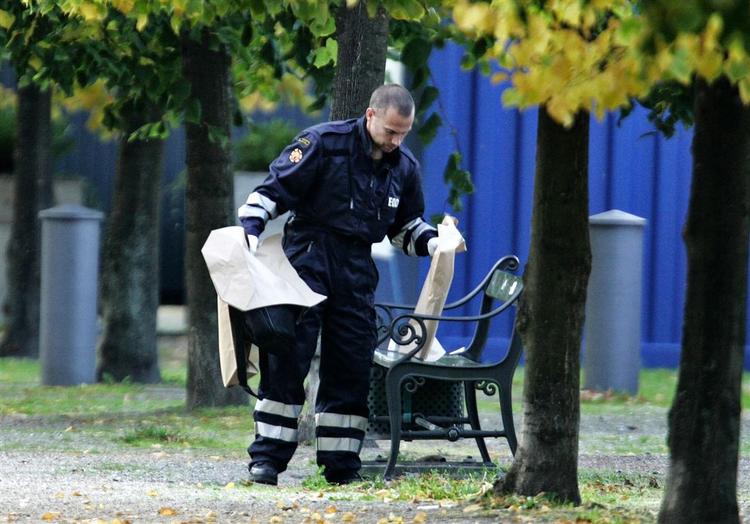 An officer removes objects on a bench outside the U.S. Embassy in Copenhagen. 