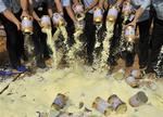 Staff members of the local quality supervision bureau empty tainted milk power packets at a garbage dump site in Shenzhen