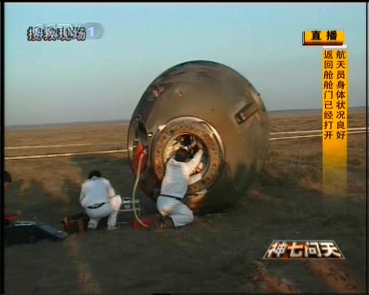 Teknikere hjælper de kinesiske astronauter ud af rumkapslen, der i dag landede på en slette i Kina. Skærmbillede fra Xinhua News Agency. 