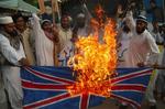 Pakistani religious protesters in Lahore in Pakistan in June  2007 burning Britain's flag over a knighthood to Salman Rushdie. 