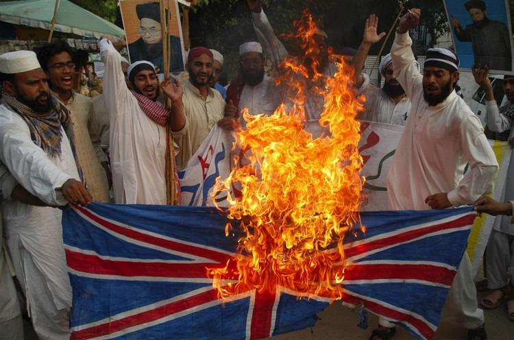 Pakistani religious protesters in Lahore in Pakistan in June  2007 burning Britain's flag over a knighthood to Salman Rushdie. 