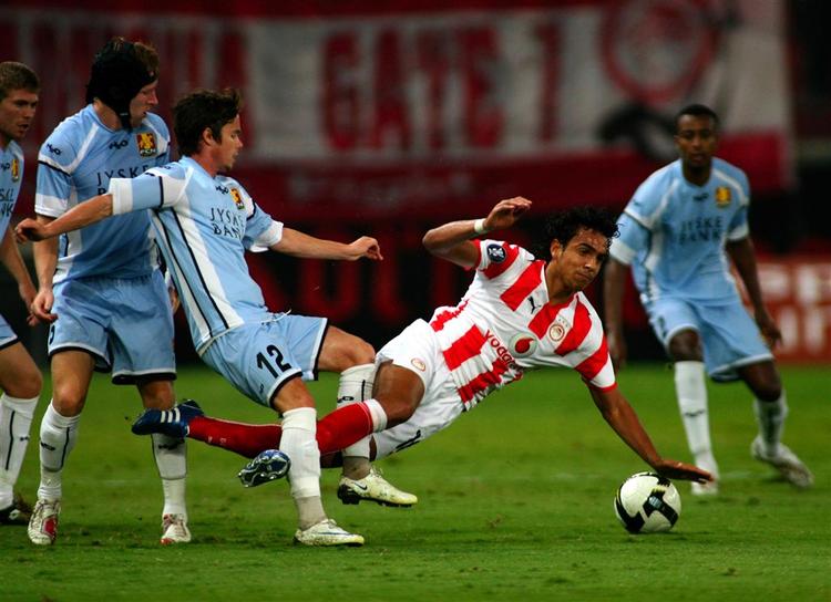 Olympiakos' Luis Santo Diogo bliver tacklet af FC Nordsjællands Bo Storm i den blå trøje. 