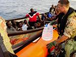 De næsten 40 somaliske bådflygtninge blev standset af Absalon og fik udleveret mad og drikke. Flygtningene håber at nå til Yemen og har på denne position kun små to timers sejltur tilbage i ders skiff-båd. Marinekonstabel Ole Jensen rækker vand over til de tørstige somalier.Foto: Frank Hvilsom 