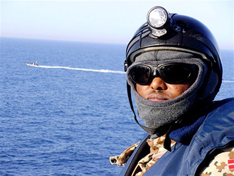 Mohamed Abdi Ali er frømandskorpsets tolk, når de border et skib. Han ønsker ikke at blive genkendt, derfor har han beholdt uniformen på. Mohamed Abdi Ali vil meget gerne citeres for sit motto: Spørg ikke, hvad verden kan gøre for dig, men hvad du kan gøre for verden.FOTO: Frank Hvilsom 