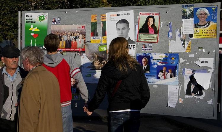 Litauerne ser på valgplakater op til parlamentsvalget. 