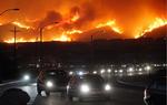 Trafikken snegler sig af sted, mens folk flygter fra flammerne. Foto fra i dag. 