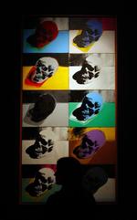 En gæst betragter Andy Warhols Skulls på Sotheby's i London. 