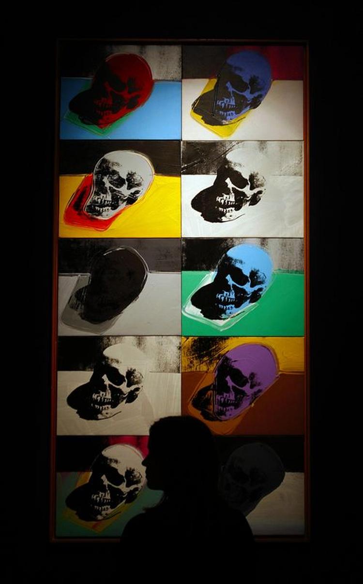 En gæst betragter Andy Warhols Skulls på Sotheby's i London. 