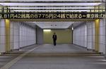 En fodgænger i Tokyo går i dag under et display, der bringer nyheden om, at aktiemarkederne åbnede med en kraftig stigning. 