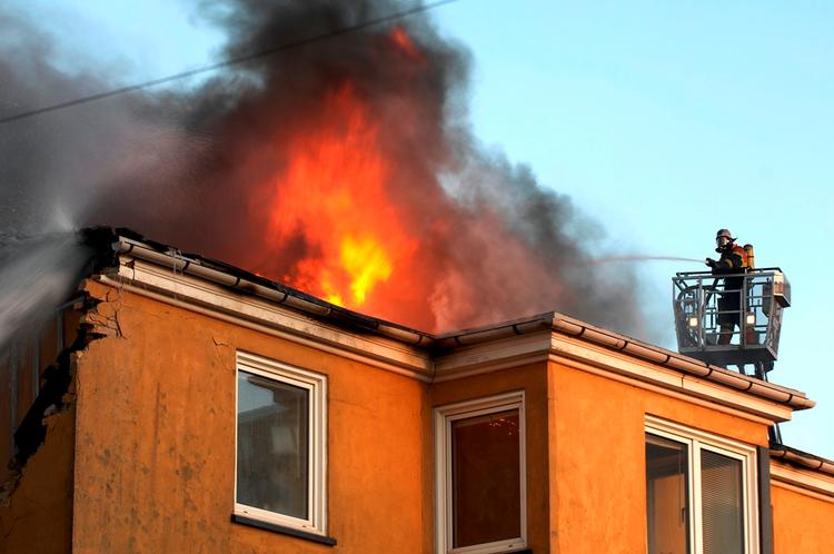 Brandfolkene har kæmpet i timevis for at slukke storbrand, der fik gavl til at blæse ud af bygning. Billedet her er taget minutter før eksplosionen. 