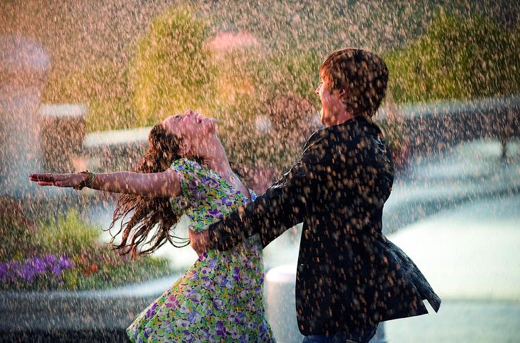KÆRLIGHEDSREGN. De store følelser har det med at plaske ned fra himlen i High School Musical. Her er det heltinden Gabriella og helten Troy, der får sig en ordentlig dukkert under nok en svingom på skolens tag. Foto: Disney 