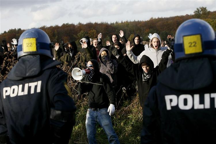 Politiet forsøger at holde demonstranterne væk fra Røde Kors' Sandholmlejr lørdag. 