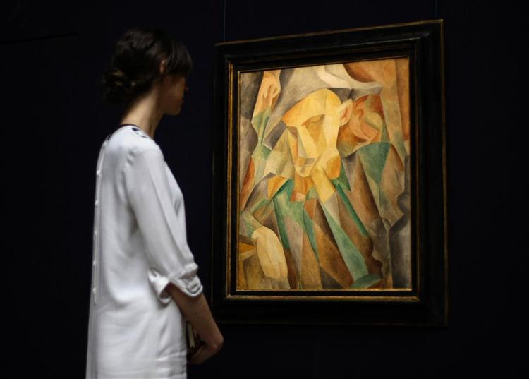 En ansat på Sotheby's betragter Picassos 'Arlequin'. Værket kommer alligevel ikke på auktion efter weekenden. 