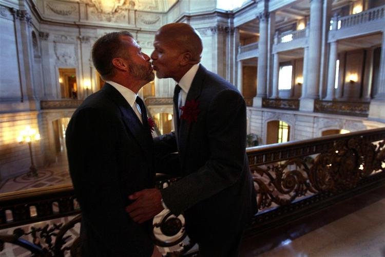 Michael Allen (tv) og Billy Iwing kysser hinanden i rådhushallen i San Francisco 21. oktober. Siden juni har det været muligt for homoseksuelle at indgå lovlige ægteskaber i Californien. I dag skal indbyggerne i staten stemme om, hvorvidt homoægteskaber skal forbydes. 