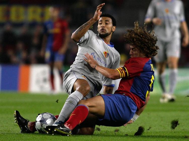 Barcelonas anfører Carles Puyol (til højre) i nærkamp med FC Basels brasilianer Carlitos. 