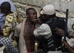 Politibetjent holder pårørende væk fra den sammenstyrtede skole i Haiti. 