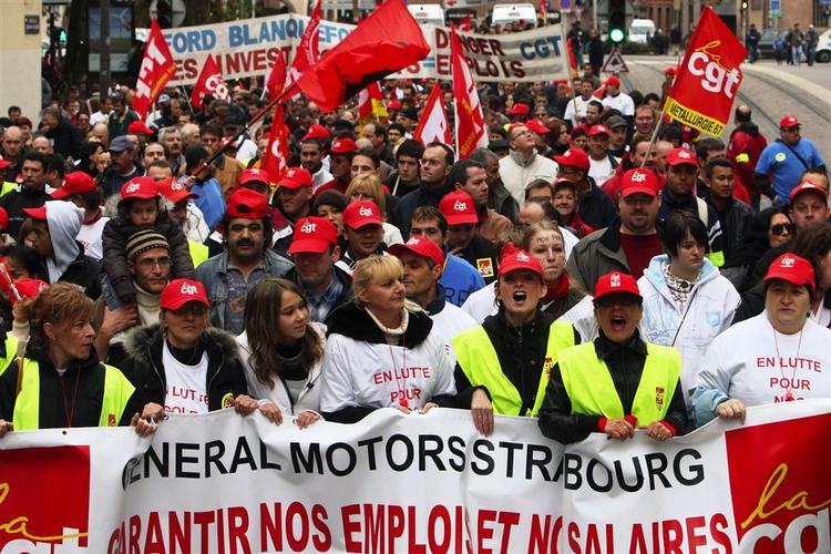 Ansatte hos General Motors i Strasbourg i demonstration mod salget af virksomhedens afdeling i byen. På banneret står der: »General Motors Strasbourg, garanter vores jobs og vores løn«. 