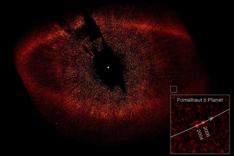 Den hvide prik i midten er stjernen Fomalhaut. To hvide prikker nederst til højre i billedet viser planeten Fomalhaut b's position i 2004 og 2006 - planetens rejse rundt om sin sol varer 872 jordår. I alt er skyen af materiale omkring solen 34,5 milliarder kilometer på tværs. 