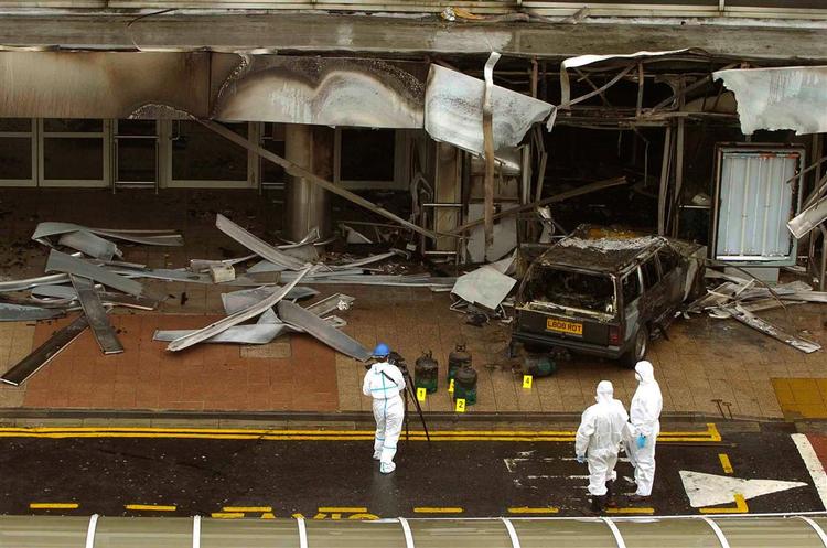 Politiets teknikere undersøgere den udbrændte bombebil ved indgangen til lufthavnen i Glasgow. 