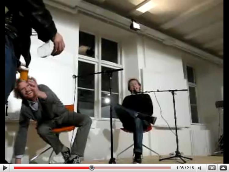 Lars Frost modtager væske på scenen. Screendump fra youtube.com 