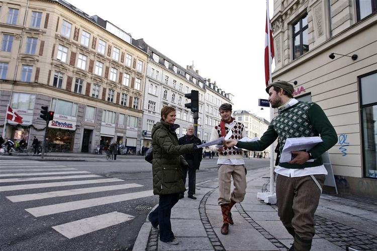 Avisdrengene deler avisartikler fra 1928 ud til folk på gaden. 