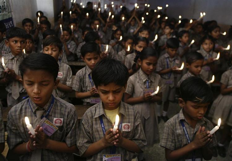 Indiske skolebørn holder tændte stearinlys for at mindes ofrene for terrorangrebene i Mumbai. 