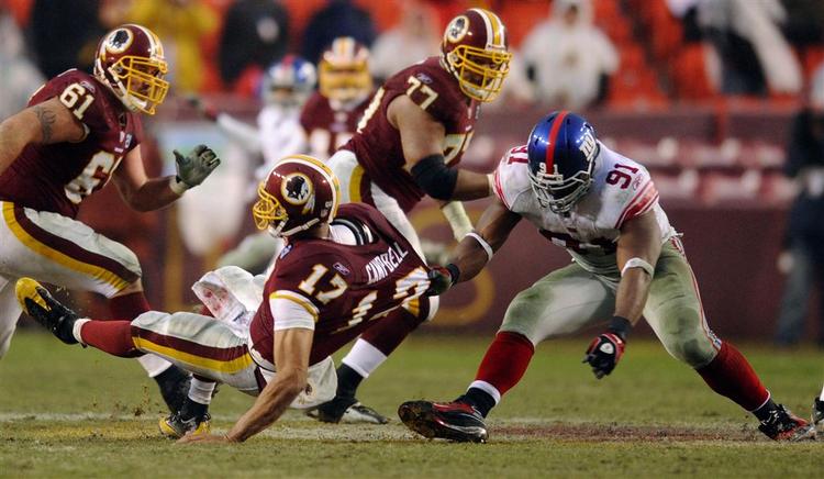 Washington Redskins quarterback Jason Campbell bliver trukket til jorden af New York Giants Justin Tuck. 