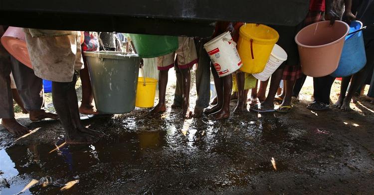 Kvinder og børn henter vand ved store FN-kølevogne i Harare. 