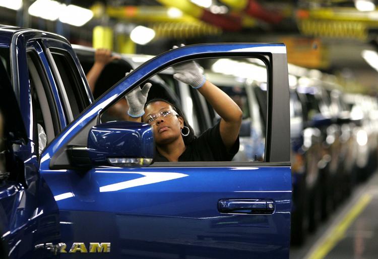 Kvindelig fabriksarbejder tjekker en dør på en ny Chrysler bil på en fabrik i Michigans tredjestørste by, Warren (arkivfoto). 