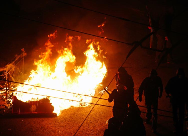 Demonstranter flygter fra en brændende skraldespand i Athen. 