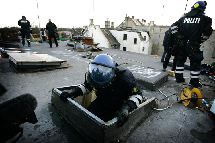 Politiet på vej ned ad loftslemmen på Ungdomshuset under rydningen 1. marts 2007. 