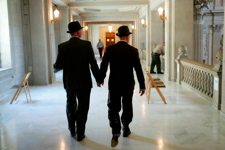 Et billede fra 17. juni, hvor Curt Garman til venstre og Richard Looke til højre holder i hånd forud for deres vielse på rådhuset i San Francisco. 