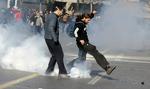 Græske demonstranter sparker tåregas tilbage til politiet foran parlamentsbygningen i det centrale Athen i dag. 