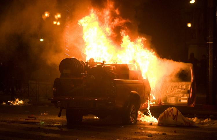 En bil er brudt i brand, efter at unge kaster brandbomber mod politiet. 
