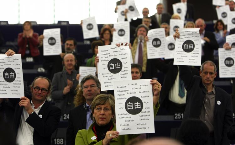 Medlemmer af EU-parlamentet holder plakater op under dagens prisuddeling, hvor der står 'frihed' på kinesisk og en række andre sprog. 