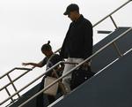 Barack Obama på vej fra flyveren og ind i Honolulus lufthavn sammen med datteren Sasha. 