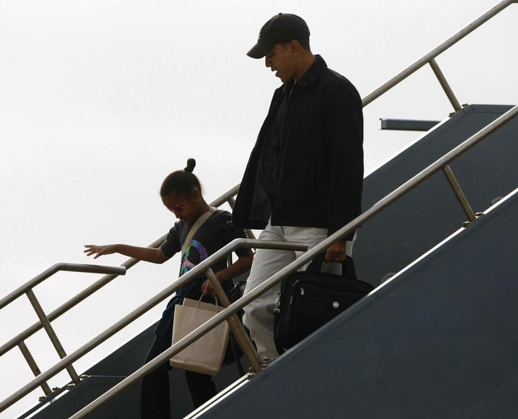 Barack Obama på vej fra flyveren og ind i Honolulus lufthavn sammen med datteren Sasha. 