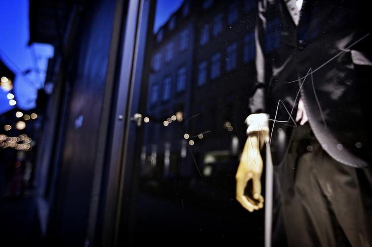 Et rids i ruden foran en butik med en herremannequin i vinduet. 