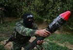 En maskeret palæstinenser viser en hjemmelavet raket frem i Gaza. 